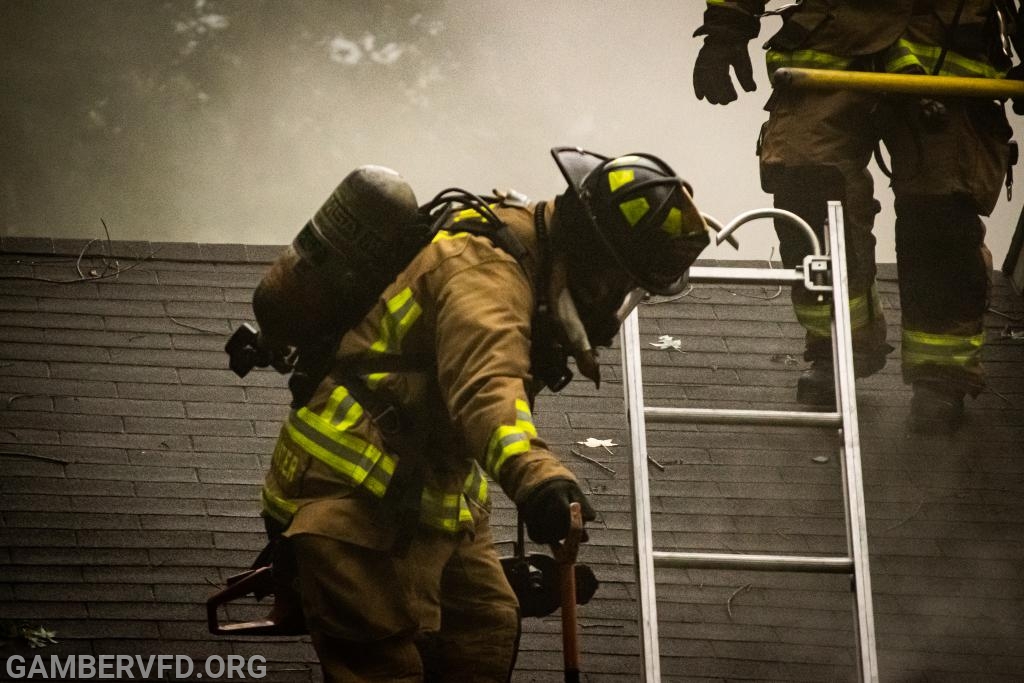 Firefighters working on the roof of a house fire in Gamber's First due area