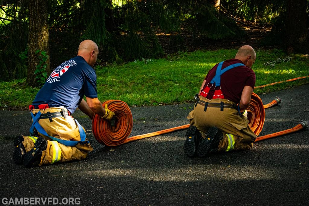 Members rolling hose after a working basement fire in Gamber's first due area